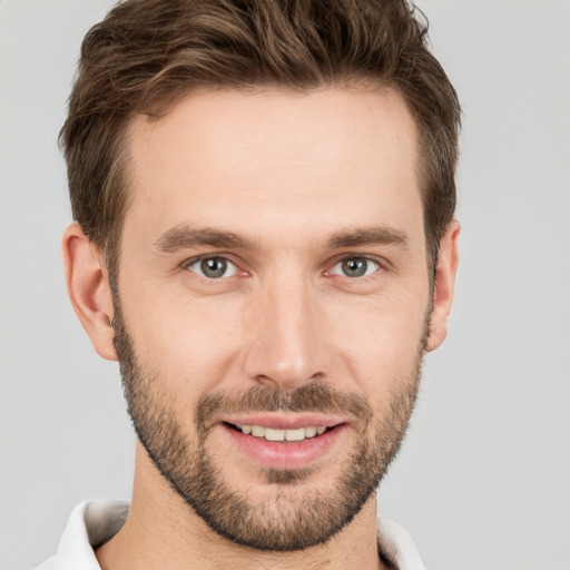 Joyful white young-adult male with short  brown hair and grey eyes