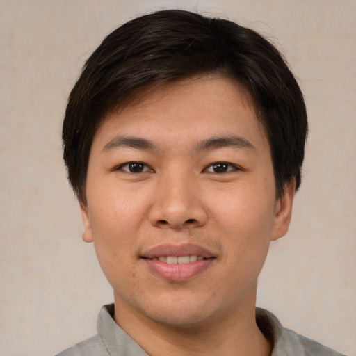 Joyful asian young-adult male with short  brown hair and brown eyes