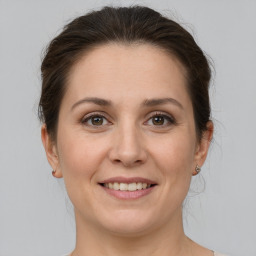 Joyful white young-adult female with medium  brown hair and grey eyes