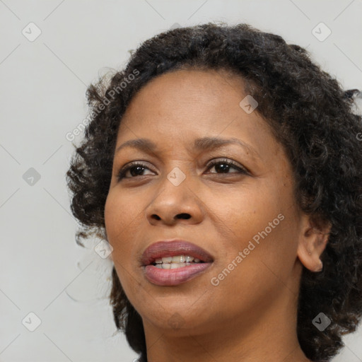 Joyful black young-adult female with long  brown hair and brown eyes