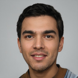 Joyful white young-adult male with short  black hair and brown eyes