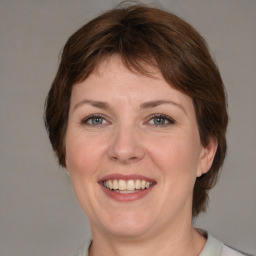 Joyful white adult female with medium  brown hair and grey eyes