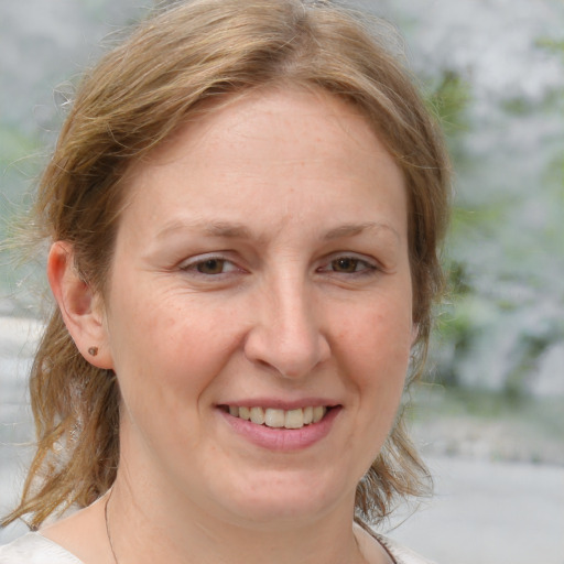 Joyful white adult female with medium  brown hair and grey eyes