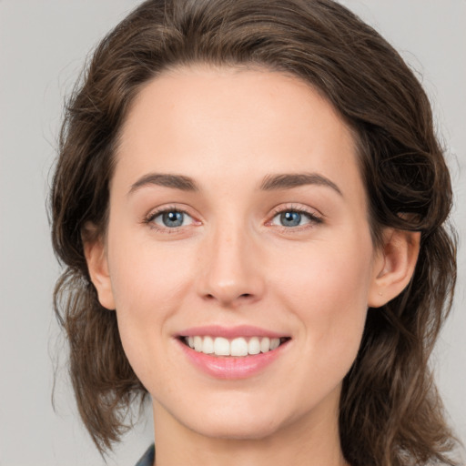 Joyful white young-adult female with medium  brown hair and green eyes