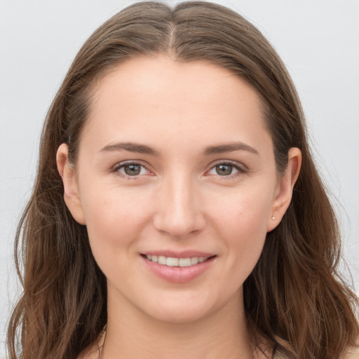 Joyful white young-adult female with long  brown hair and grey eyes