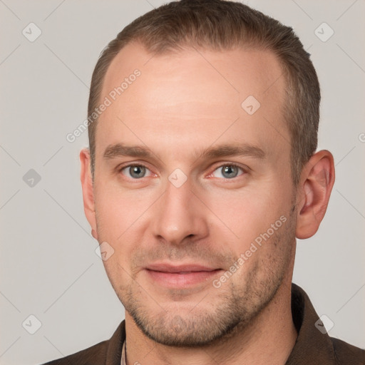 Joyful white young-adult male with short  brown hair and grey eyes