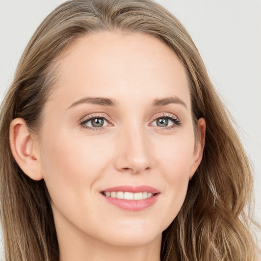 Joyful white young-adult female with long  brown hair and blue eyes