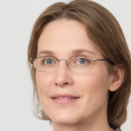 Joyful white adult female with medium  brown hair and grey eyes