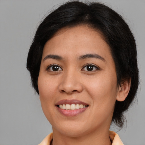 Joyful asian young-adult female with medium  brown hair and brown eyes