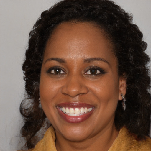Joyful black young-adult female with medium  brown hair and brown eyes