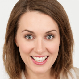 Joyful white young-adult female with long  brown hair and green eyes