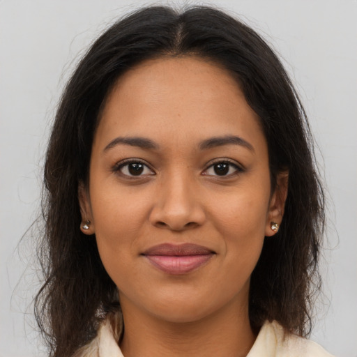 Joyful latino young-adult female with medium  brown hair and brown eyes