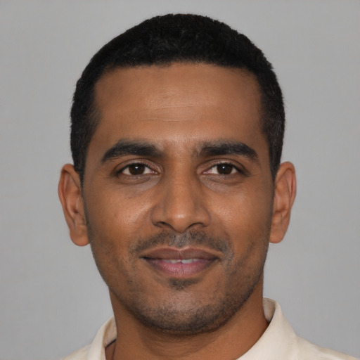 Joyful black young-adult male with short  black hair and brown eyes