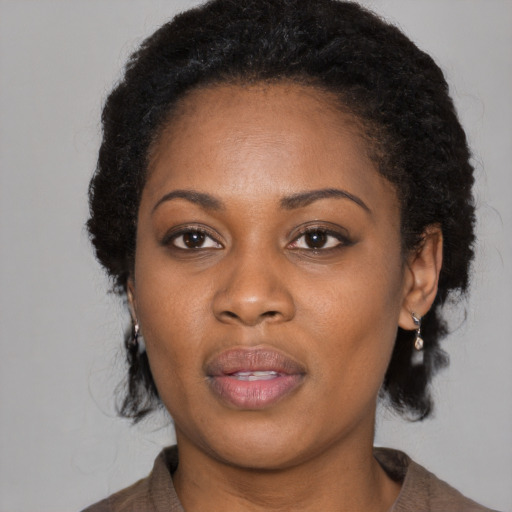 Joyful black adult female with long  black hair and brown eyes