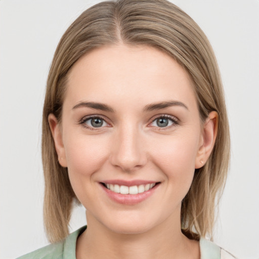 Joyful white young-adult female with medium  brown hair and grey eyes