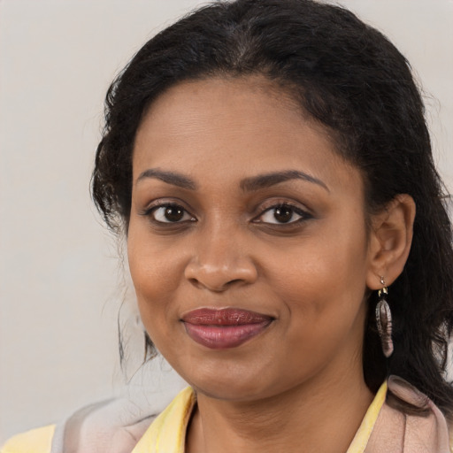 Joyful black young-adult female with long  brown hair and brown eyes