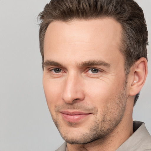 Joyful white adult male with short  brown hair and brown eyes