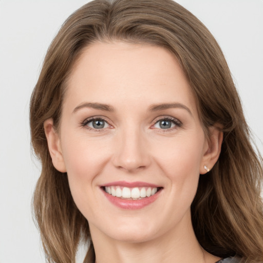 Joyful white young-adult female with medium  brown hair and grey eyes