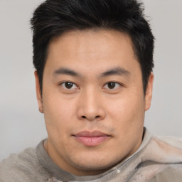 Joyful asian young-adult male with short  brown hair and brown eyes