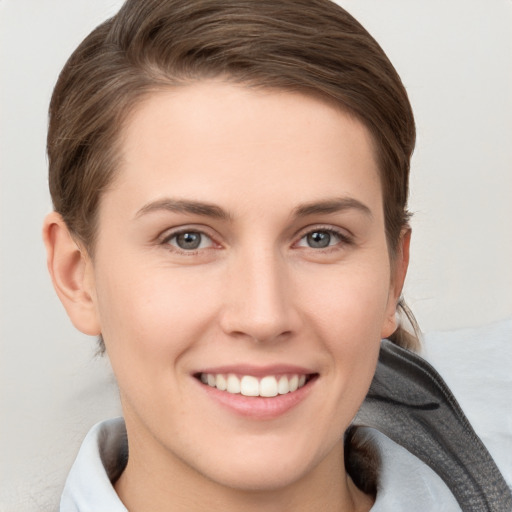 Joyful white young-adult female with short  brown hair and grey eyes