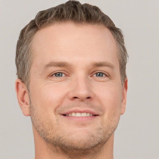 Joyful white adult male with short  brown hair and grey eyes