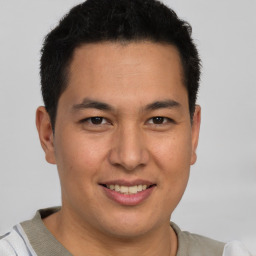 Joyful latino young-adult male with short  brown hair and brown eyes