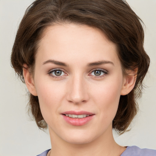 Joyful white young-adult female with medium  brown hair and green eyes