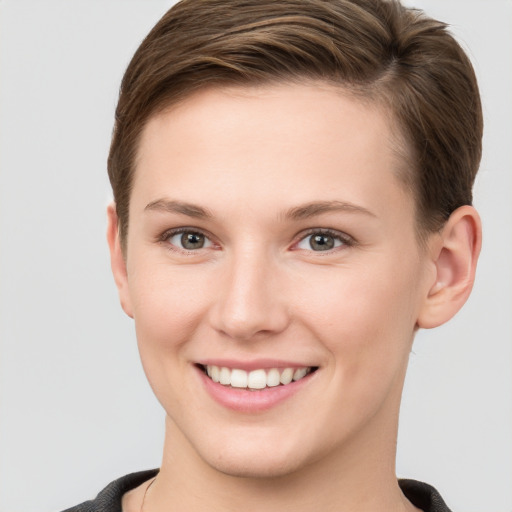 Joyful white young-adult female with short  brown hair and grey eyes