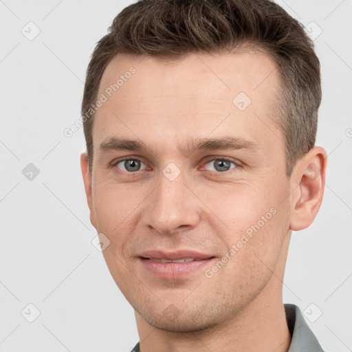 Joyful white young-adult male with short  brown hair and grey eyes