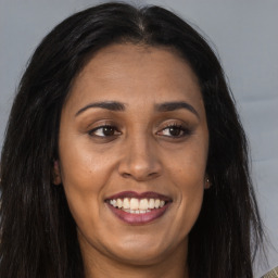 Joyful latino young-adult female with long  brown hair and brown eyes