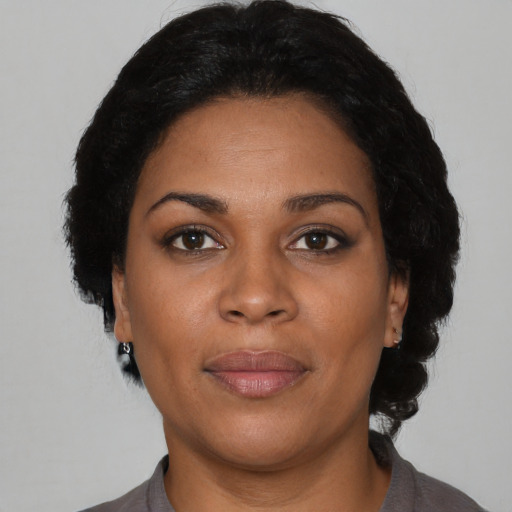 Joyful black young-adult female with short  brown hair and brown eyes