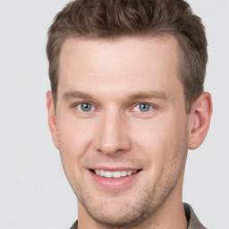 Joyful white young-adult male with short  brown hair and grey eyes