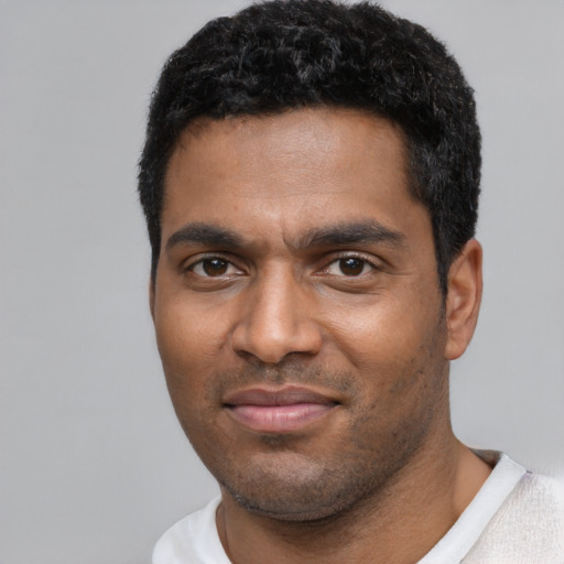 Joyful black young-adult male with short  black hair and brown eyes