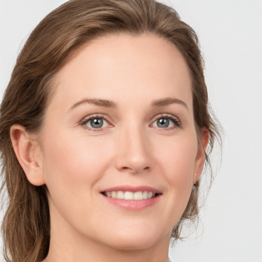 Joyful white young-adult female with medium  brown hair and grey eyes