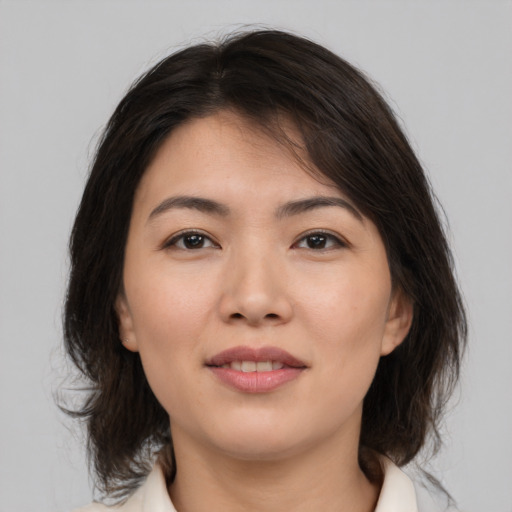 Joyful asian young-adult female with medium  brown hair and brown eyes