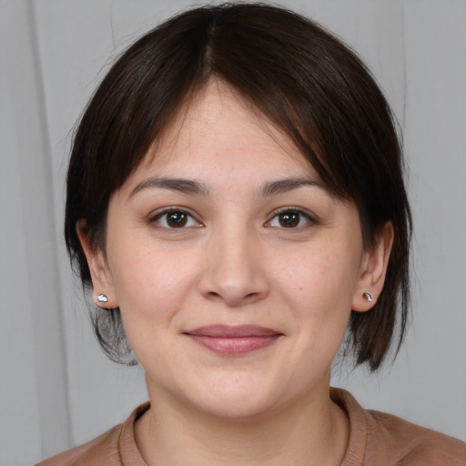 Joyful white young-adult female with medium  brown hair and brown eyes