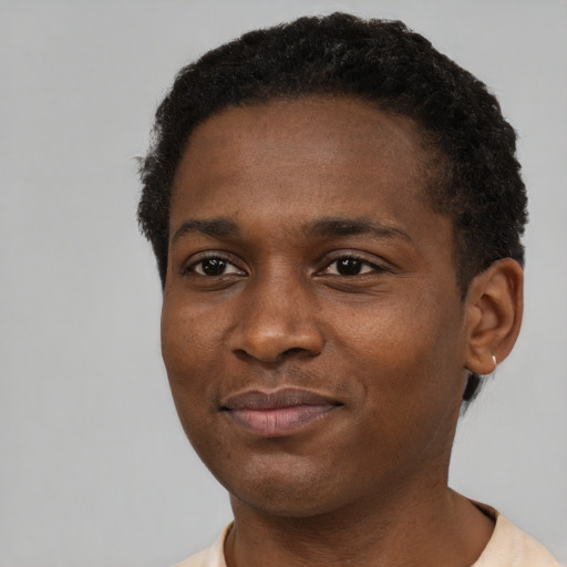 Joyful black young-adult male with short  brown hair and brown eyes
