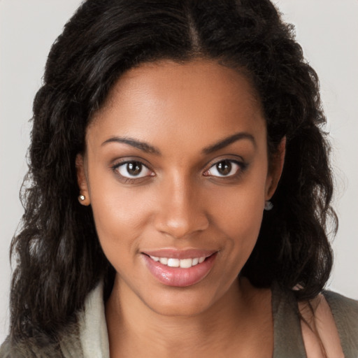 Joyful black young-adult female with long  brown hair and brown eyes