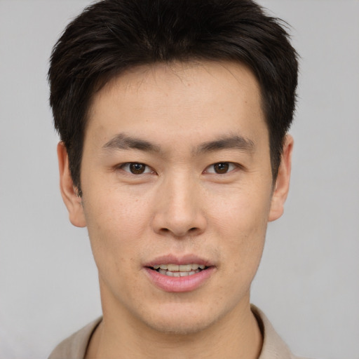 Joyful asian young-adult male with short  brown hair and brown eyes