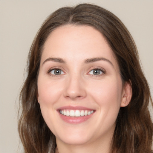 Joyful white young-adult female with long  brown hair and grey eyes