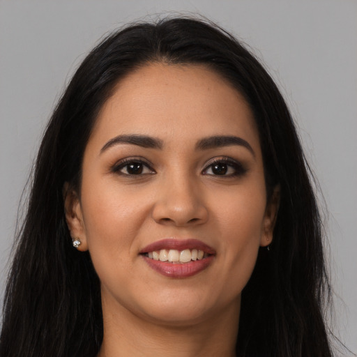 Joyful latino young-adult female with long  brown hair and brown eyes