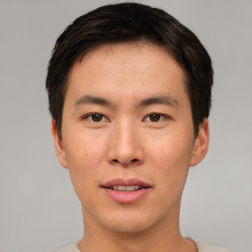 Joyful asian young-adult male with short  brown hair and brown eyes
