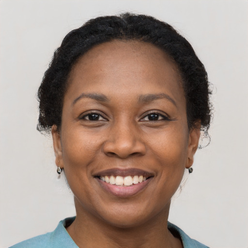 Joyful black adult female with short  brown hair and brown eyes