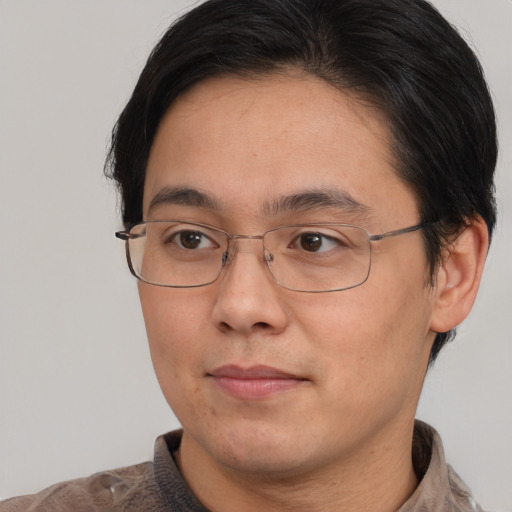 Joyful asian adult male with short  brown hair and brown eyes