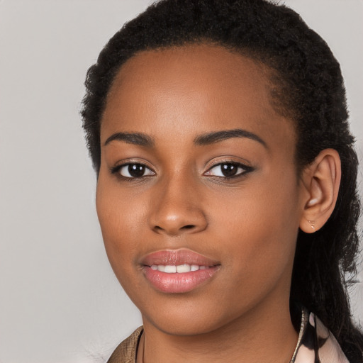 Joyful black young-adult female with long  brown hair and brown eyes