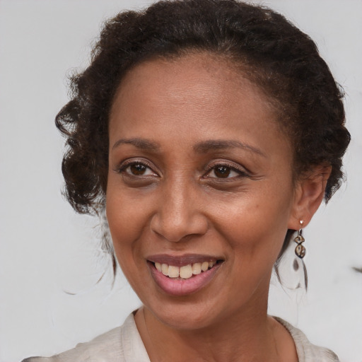 Joyful black adult female with medium  brown hair and brown eyes