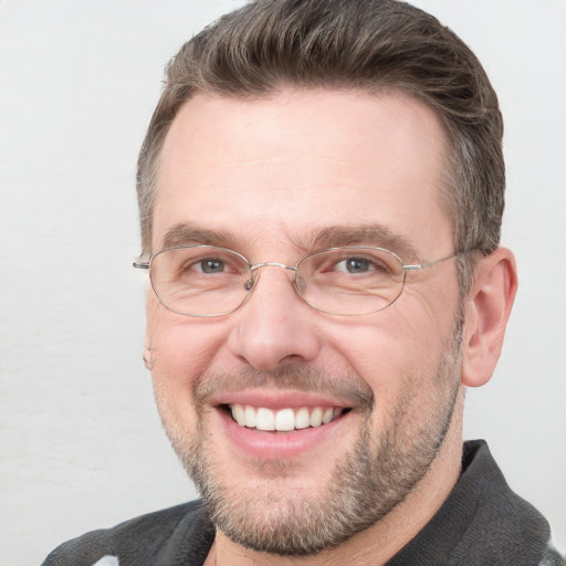 Joyful white adult male with short  brown hair and blue eyes