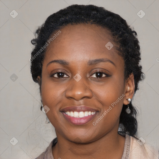 Joyful black young-adult female with long  black hair and brown eyes