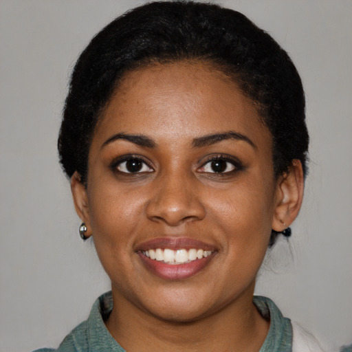 Joyful black young-adult female with short  black hair and brown eyes