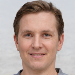 Joyful white adult male with short  brown hair and grey eyes